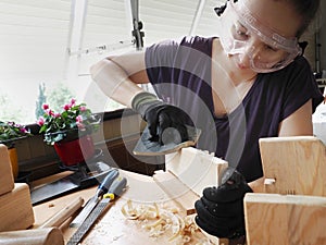 A woman doing wooden handicraft in the balcony