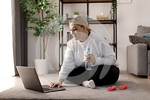 Woman doing workout with laptop