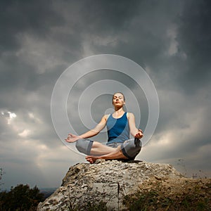 Woman doing yoga against the setting sun