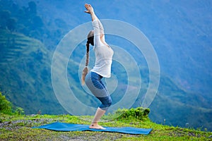 Woman doing yoga asana Utkatasana outdoors