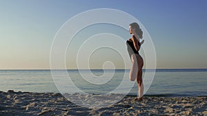 Woman doing yoga on the beach against the backdrop of the sea or ocean. yoga fitness and healthy lifestyle. sun, sea, summer. 4k.