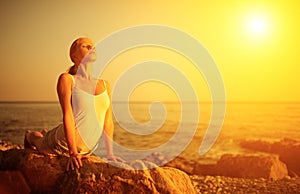 Woman doing yoga on the beach at sunset