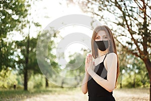 Woman doing yoga on the beach wearing a mask