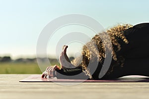 Woman doing yoga exercise away from city life