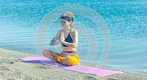 Woman doing yoga exercise on the beach, woman relaxing on the beach, woman doing yoga