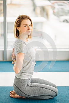 Woman doing yoga exercise on mat in Virasana or Hero Pose