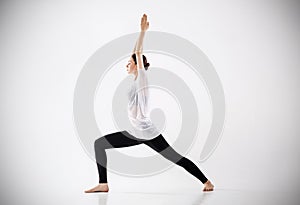 Woman doing yoga exercise. In warrior possition.