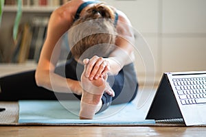 woman doing yoga at home watching online videos