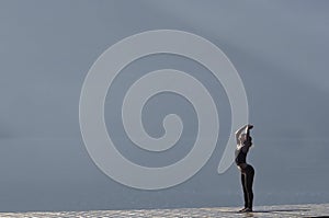 Woman doing yoga by the lake