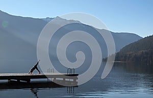 Woman doing yoga by the lake