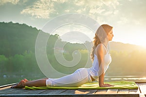 Woman doing yoga on the lake