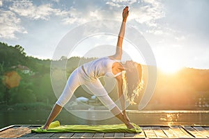 Woman doing yoga on the lake