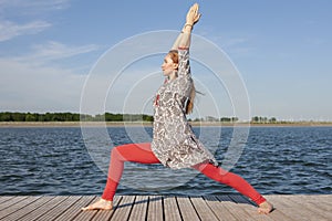 Woman doing yoga on the lake - relaxing in nature