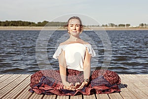 Woman doing yoga on the lake - relaxing in nature