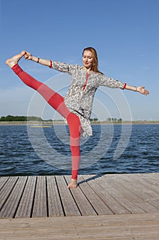 Woman doing yoga on the lake - relaxing in nature