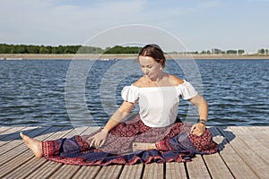 Woman doing yoga on the lake - relaxing in nature