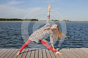 Woman doing yoga on the lake - relaxing in nature