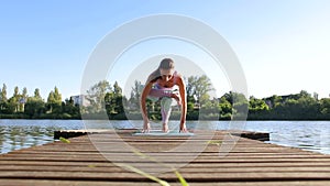 Woman doing yoga on the lake- relaxing in nature.