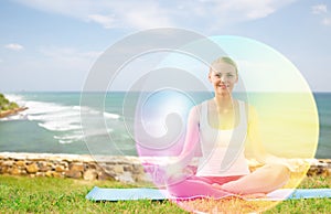 Woman doing yoga in lotus pose with rainbow aura