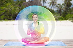 Woman doing yoga in lotus pose with rainbow aura