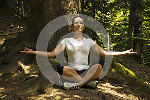 Woman doing yoga in lotus position outdoors