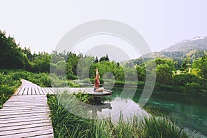 Woman doing yoga and meditating in lotus position on the nature.