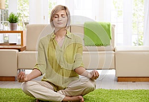 Woman doing yoga meditation at home photo