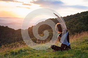 Woman doing yoga meditation in the mountains at dawn