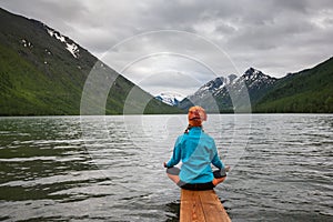 Woman is doing yoga at Multinskoe lake