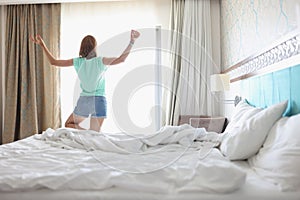 Woman doing yoga near light window in bedroom with stylish interior