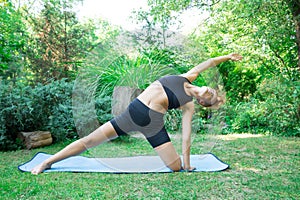 Woman doing yoga in the park, the concept of a healthy lifestyle