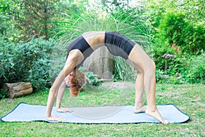 Woman doing yoga in the park, the concept of a healthy lifestyle