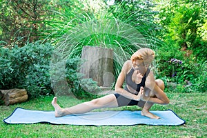 Woman doing yoga in the park, the concept of a healthy lifestyle