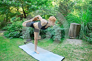 Woman doing yoga in the park, the concept of a healthy lifestyle