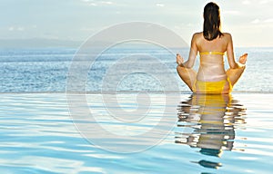 Woman doing yoga at poolside