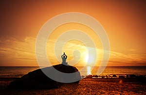 Woman doing yoga pose at sunset