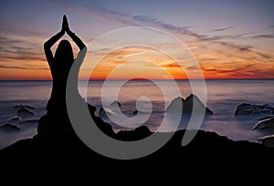 Woman doing yoga pose at sunset