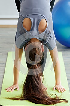 Woman doing yoga practice, they standing and stretch the bodies and lower their head down to floor. The concept for self-care