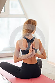 woman doing yoga in reverse prayer pose. Pashchima Namaskarasana