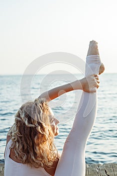 Woman Doing Yoga By The Sea