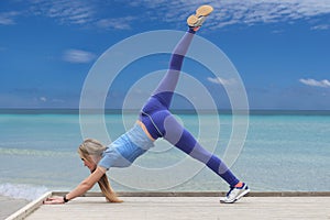 Woman doing yoga by the sea