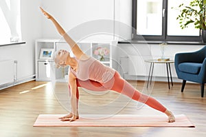 Woman doing yoga and side angle pose at home