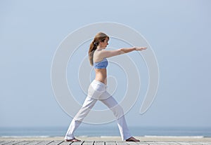 Woman doing yoga stretch at the beach