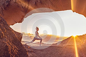 Woman doing yoga, stretching, meditating on the top of a mountain