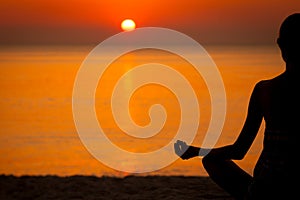 Woman doing Yoga at sunset