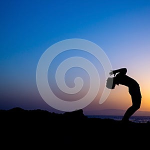 Woman doing yoga sunset silhouette