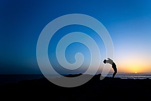 Woman doing yoga sunset silhouette