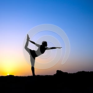 Woman doing yoga sunset silhouette