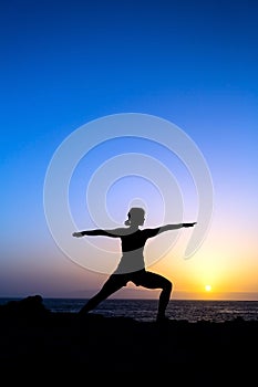 Woman doing yoga sunset silhouette