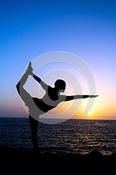 Woman doing yoga sunset silhouette